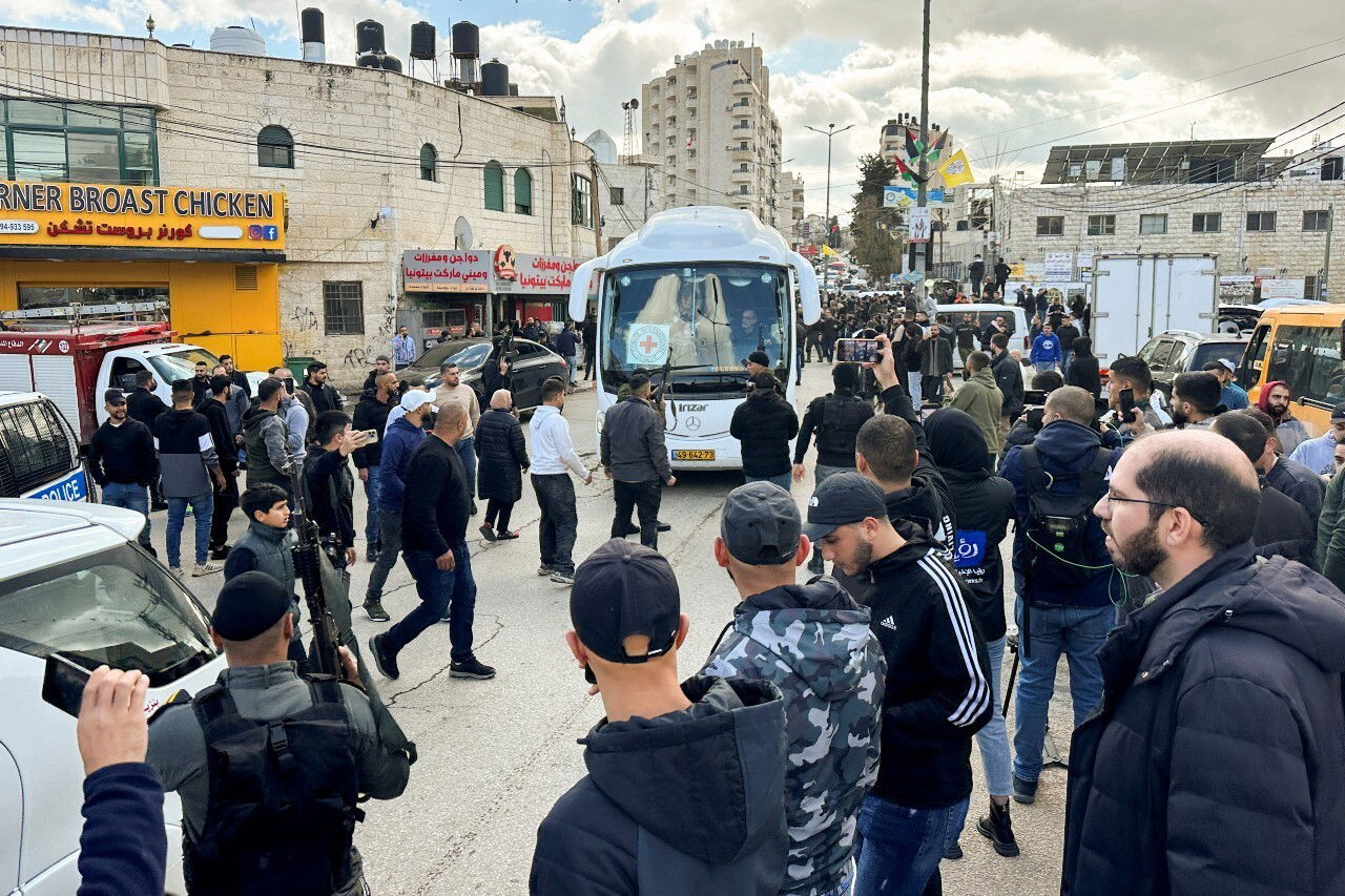 Several people crowd around a bus.