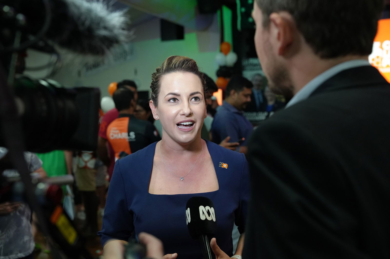 A woman wearing a navy dress talks to an ABC reporter.