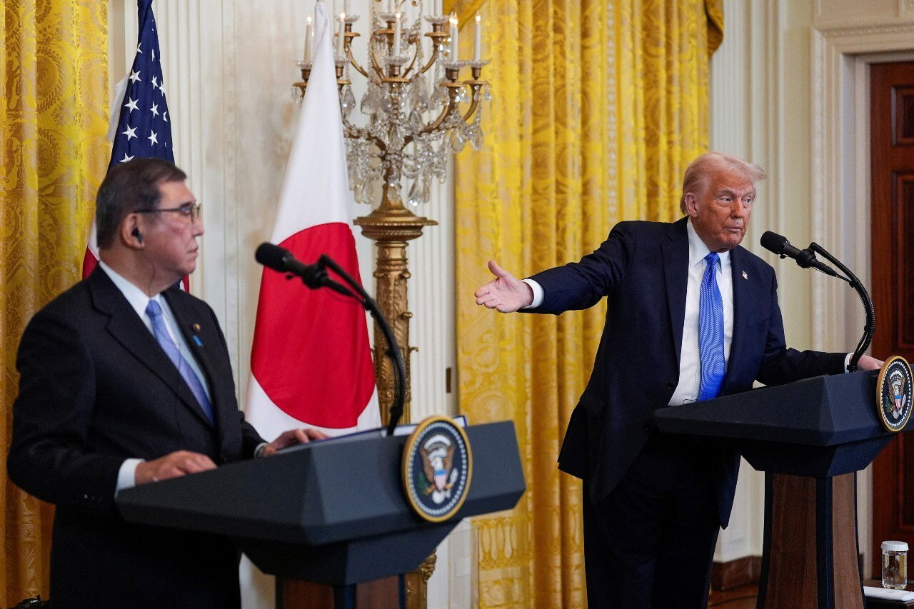 Two men standing at lecturns, speaking.