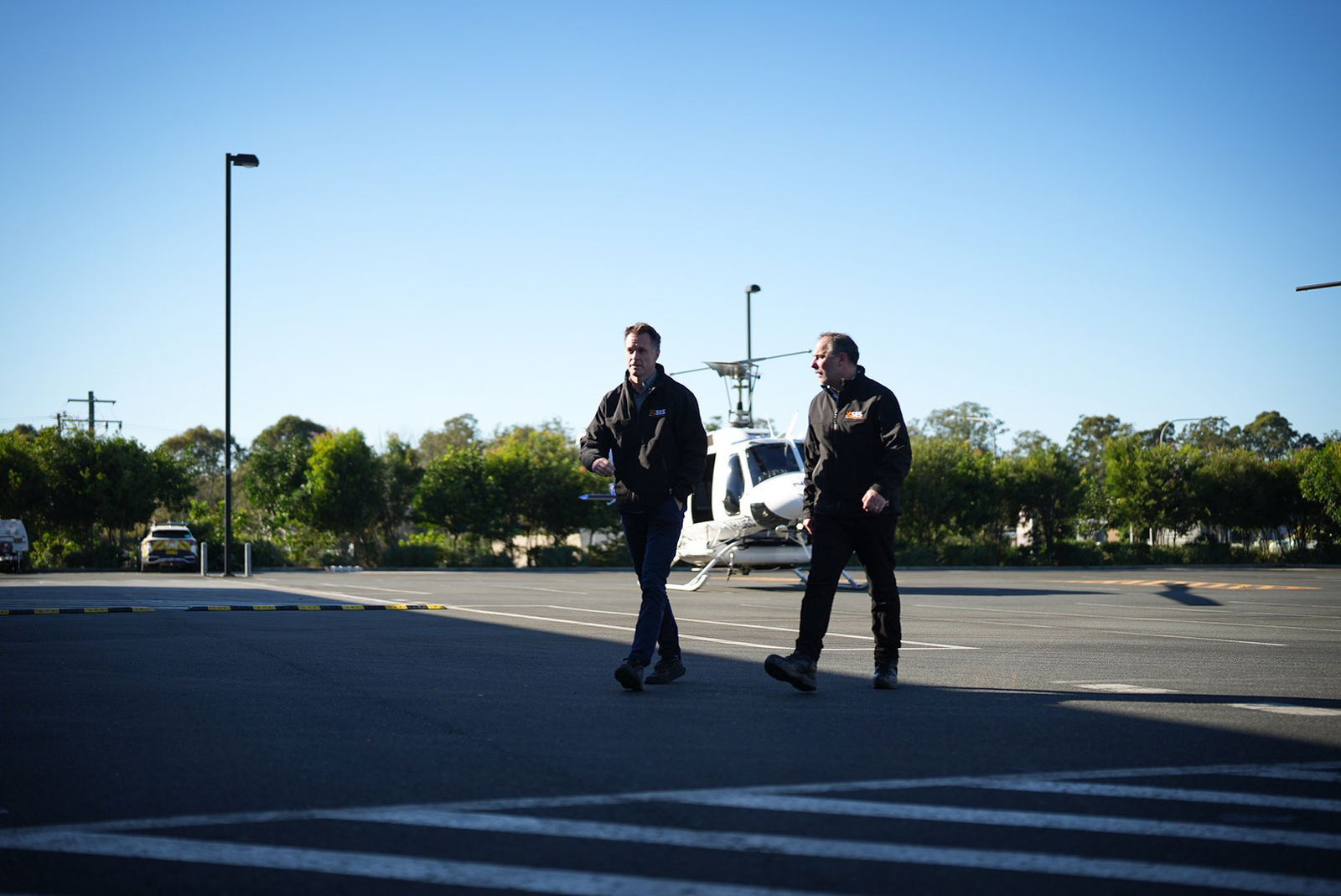 NSW Premier Chris Minns walks with a man across the tarmac at an airport