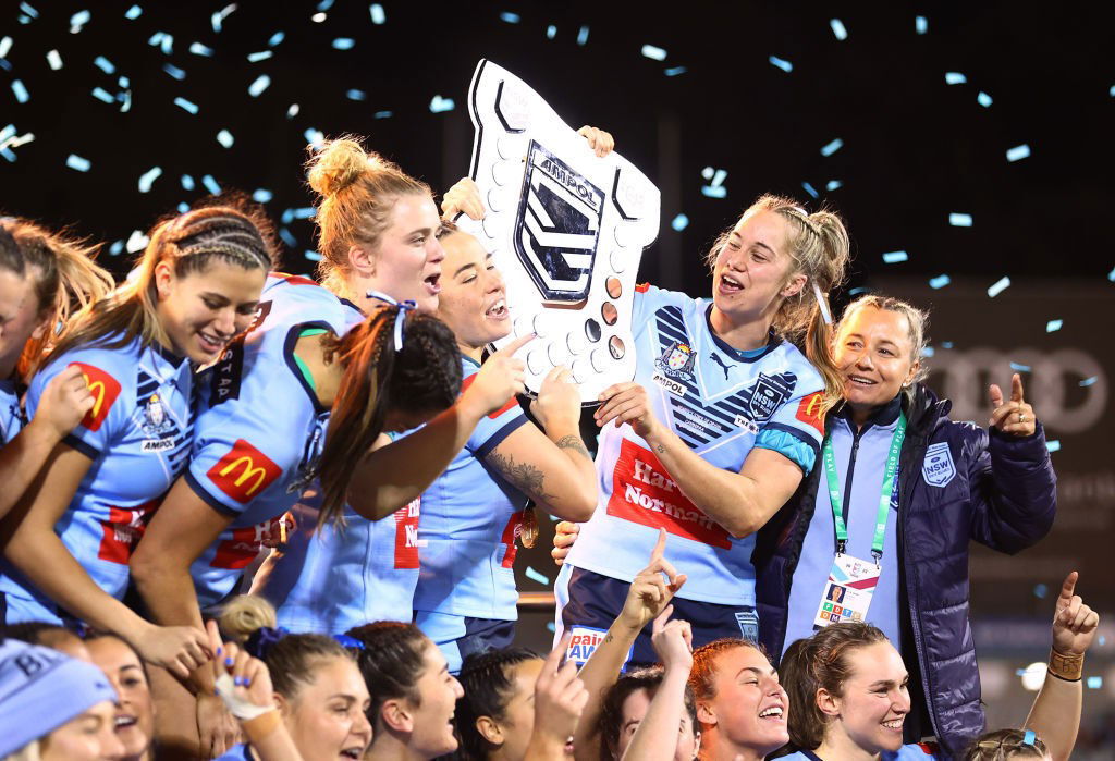 NSW Blues players hold the Women's State of Origin shield.