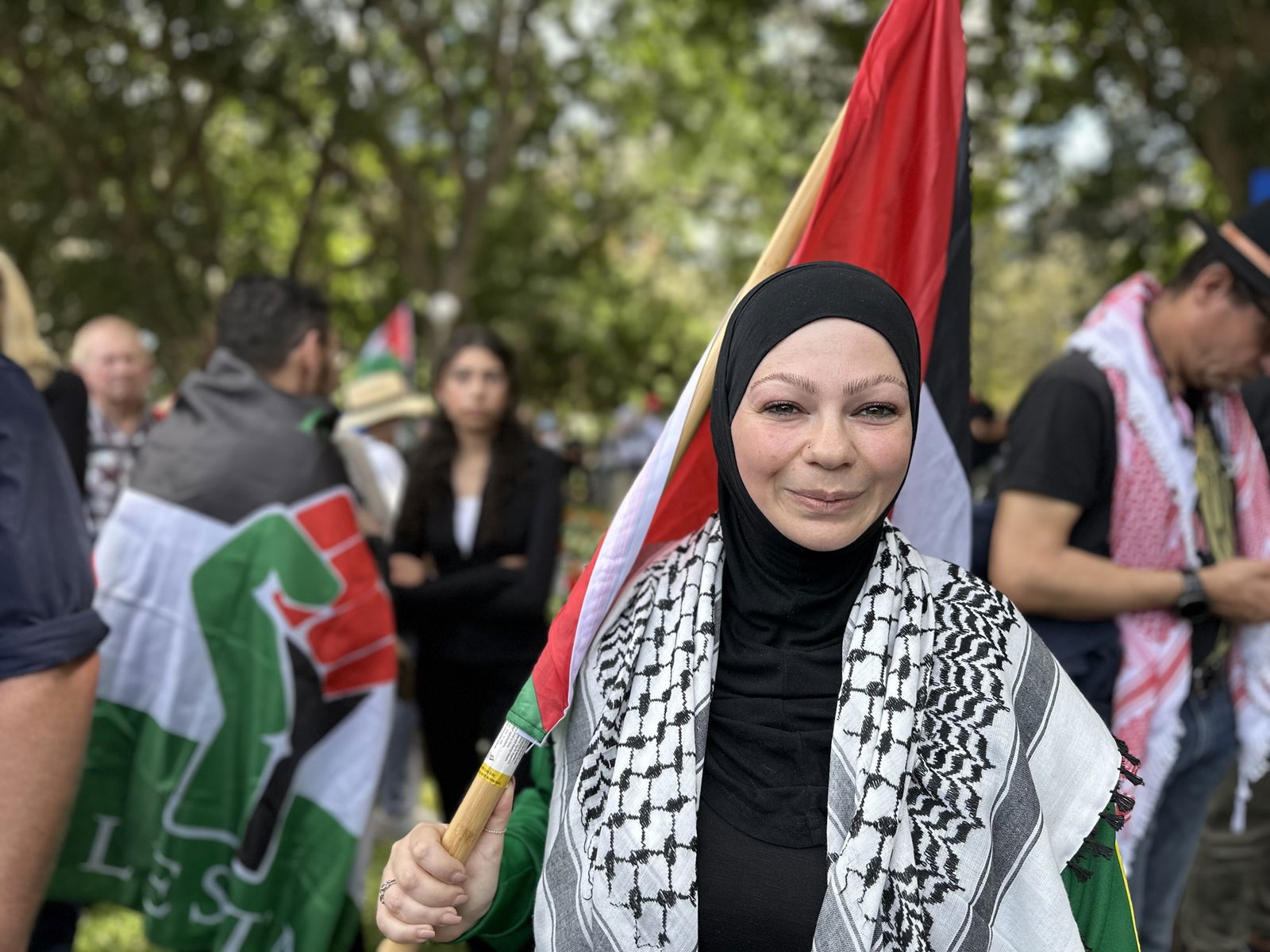 A woman carrying a Palestinian flag