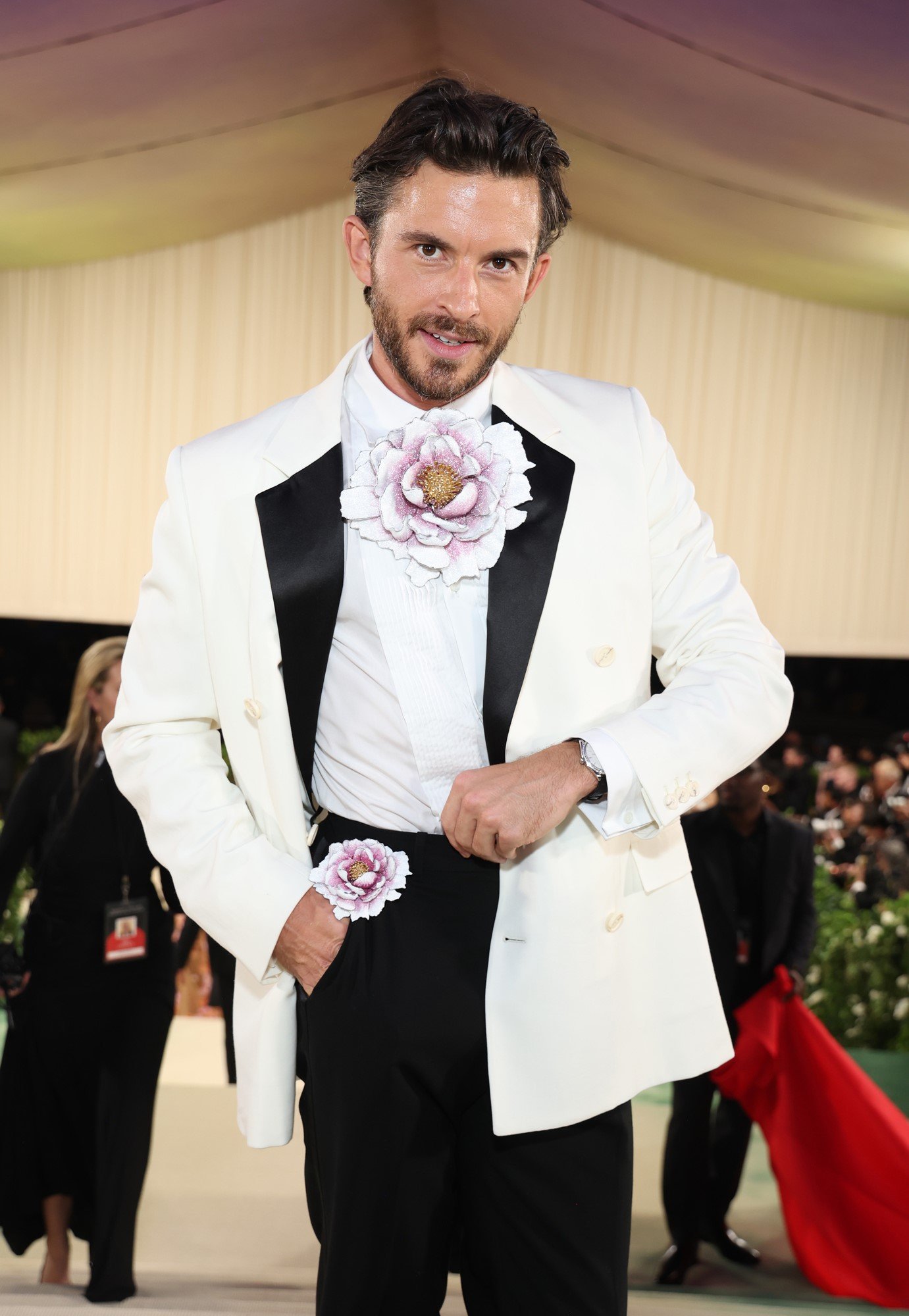 Jonathan wears a white blazer with a flower on his chest and in his pocket.