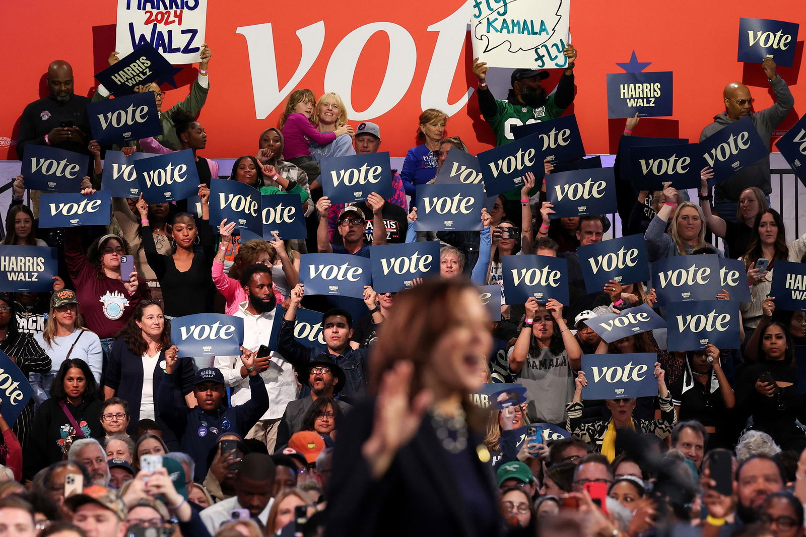 Supporters hold placards in the crowd of a Harris rally