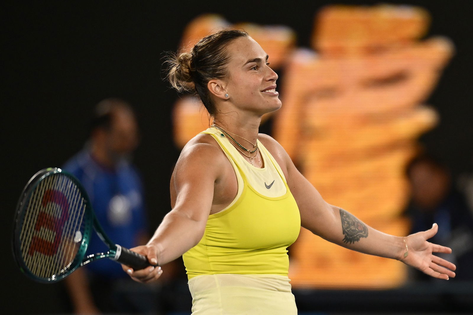 Aryna Sabalenka holds her arms out.