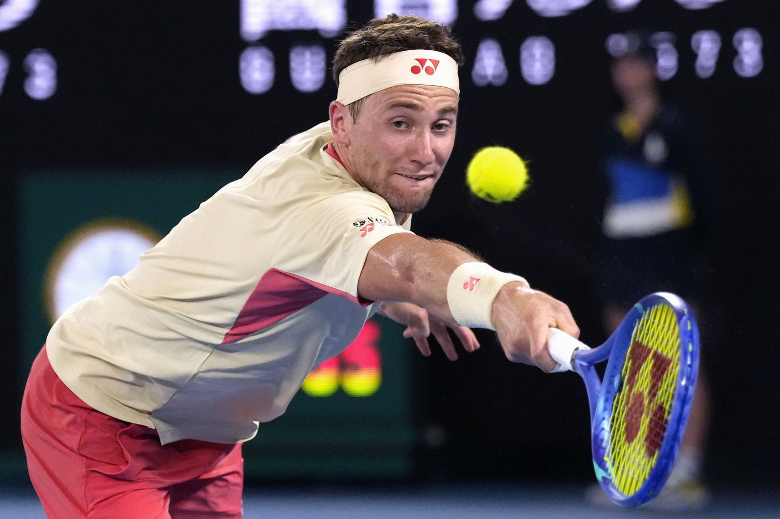 Tennis player Casper Ruud stretches for a  backhand.