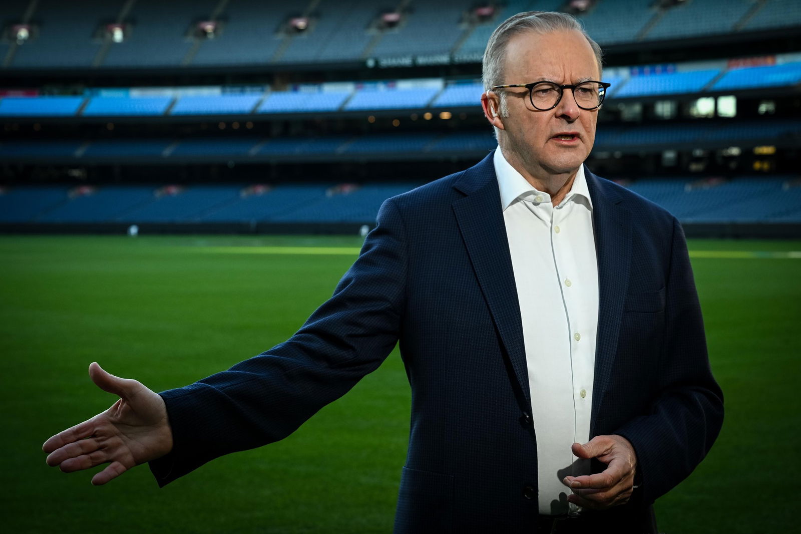 a man in a suit on a footy oval
