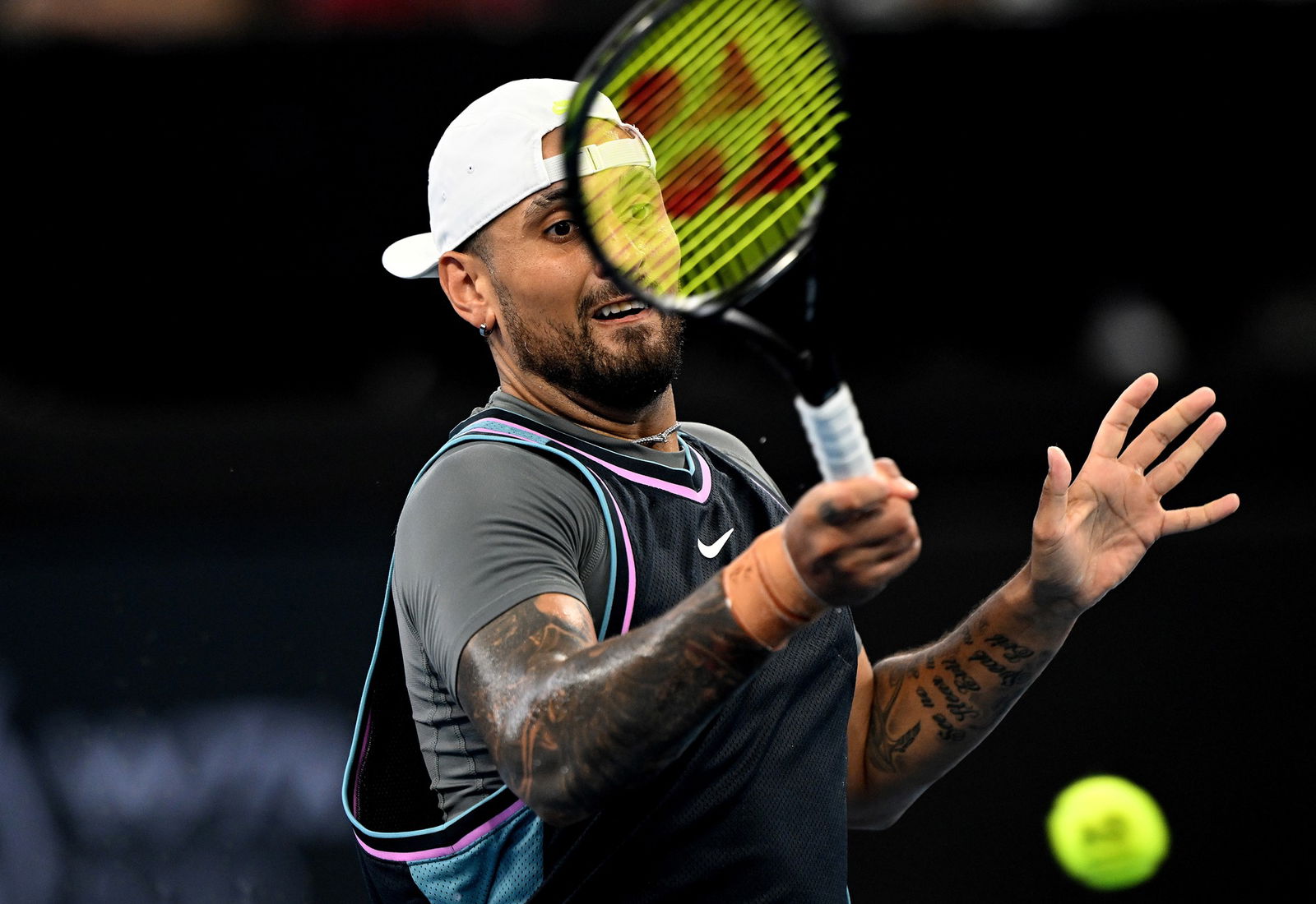 Nick Kyrgios plays a forehand return.