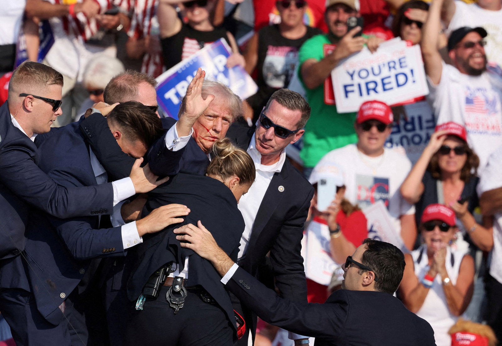 Secret Service agents haul Trump off the stage after a bullet skims his ear