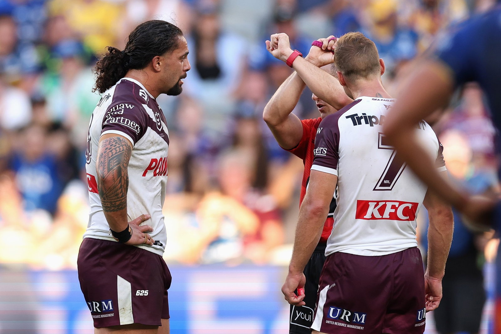 An NRL referee crosses his arms to put Manly Sea Eagles player Josh Aloiai on report. Daly Cherry-Evans is there too.