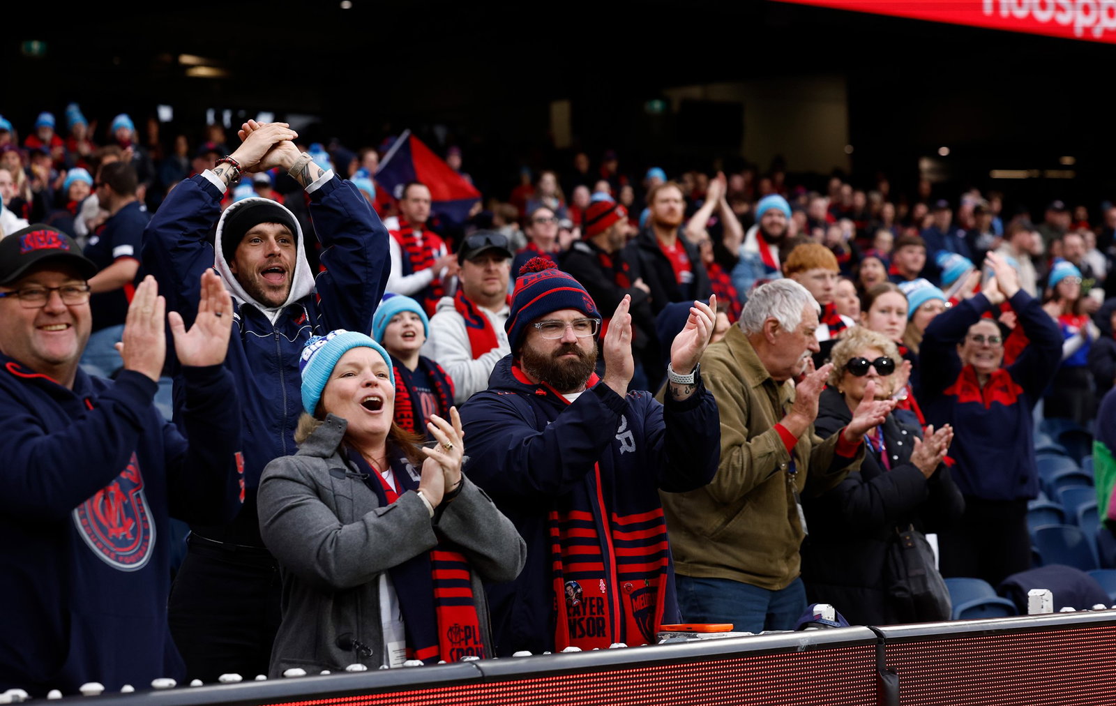 Fans applaud at the 6 minute mark in memory of Neale Daniher during the 2026 AFL Round 14 match between the Melbourne Demons and the Essendon Bombers at the Melbourne Cricket Ground on June 13, 2026 in Melbourne, Australia.