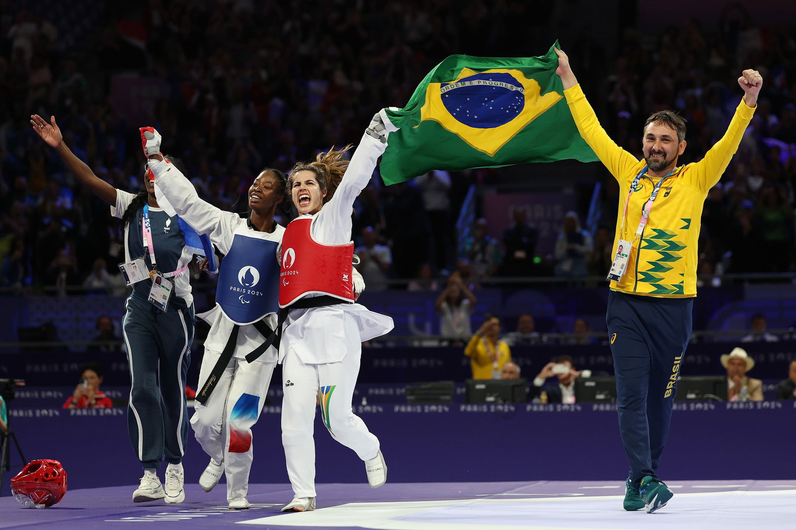 Brazil's Ana Carolina Silva de Moura celebrates with France's Djelika Diallo after the women's K44-65kg gold medal match in taekwondo.