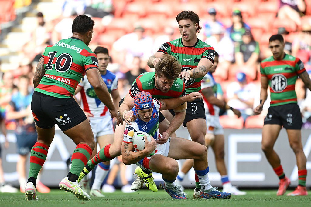 Kalyn Ponga is tackled by Rabbitohs players during an NRL game.