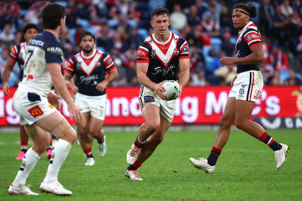 Joey Manu runs with the ball for the Sydney Roosters in an NRL game.
