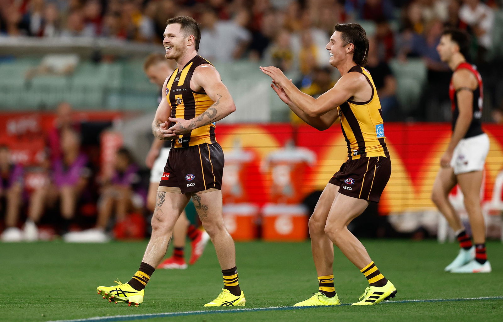 Two Hawks players celebrate a goal.