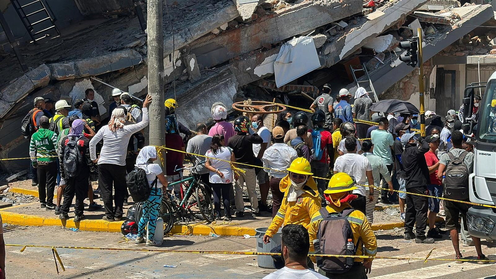 Search volunteers standing next to a destroyed building