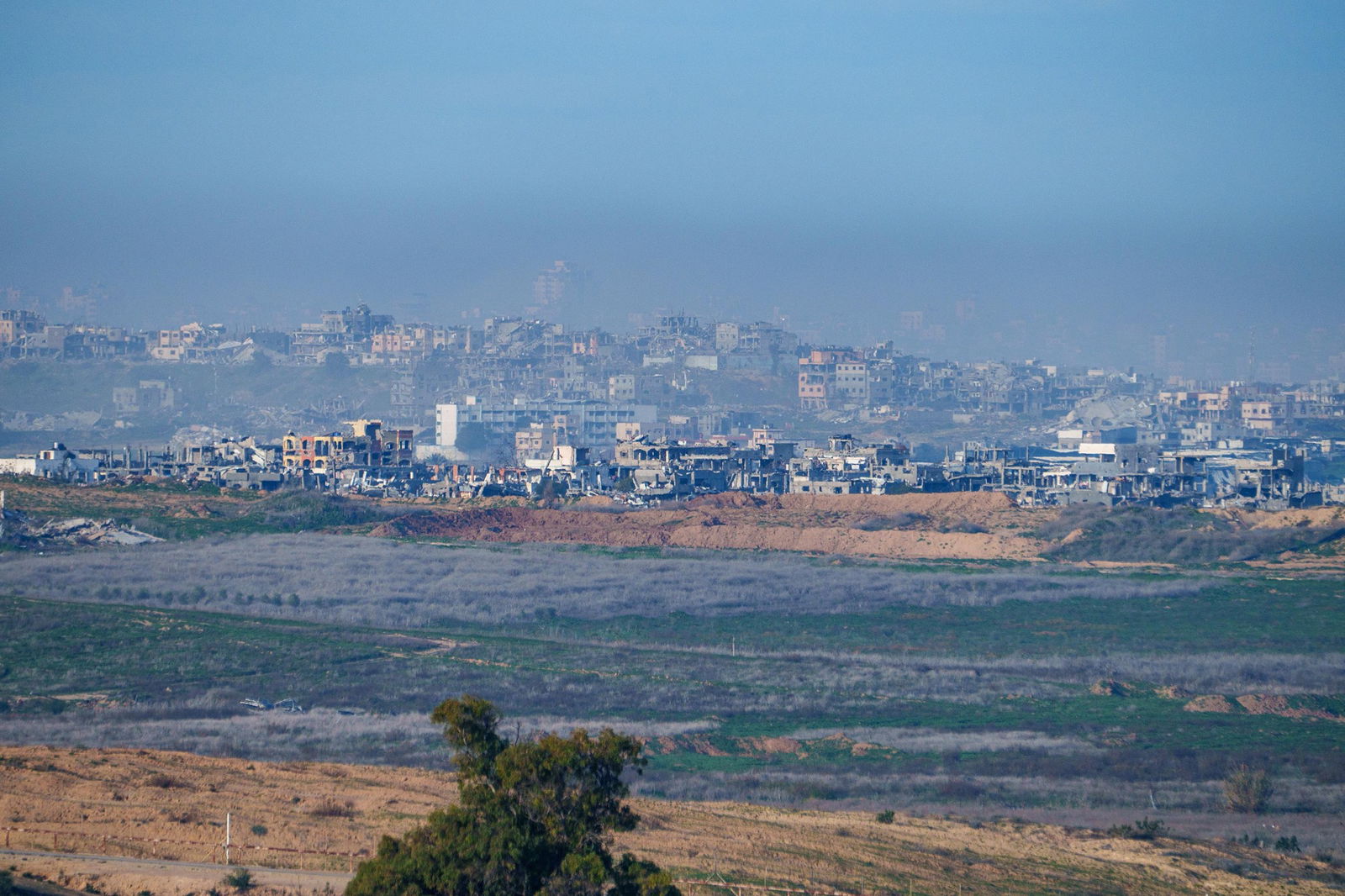 An entire neighbourhood turned to rubble, seen from a distance.