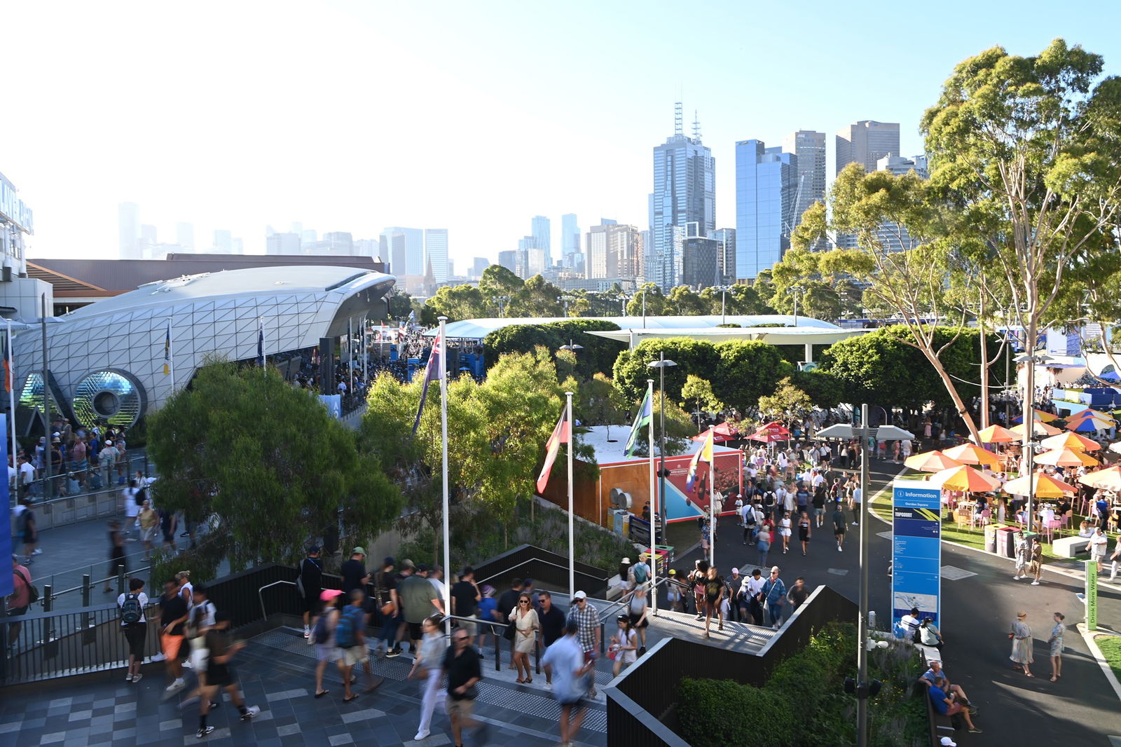 Melbourne Park with people walking around and a view of the city in background