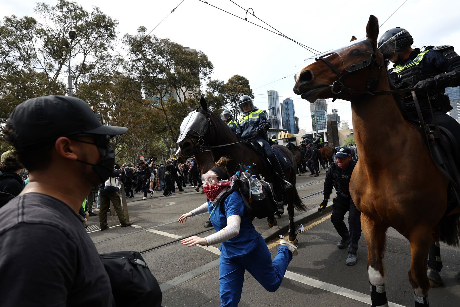 Mounted police chasing a protester