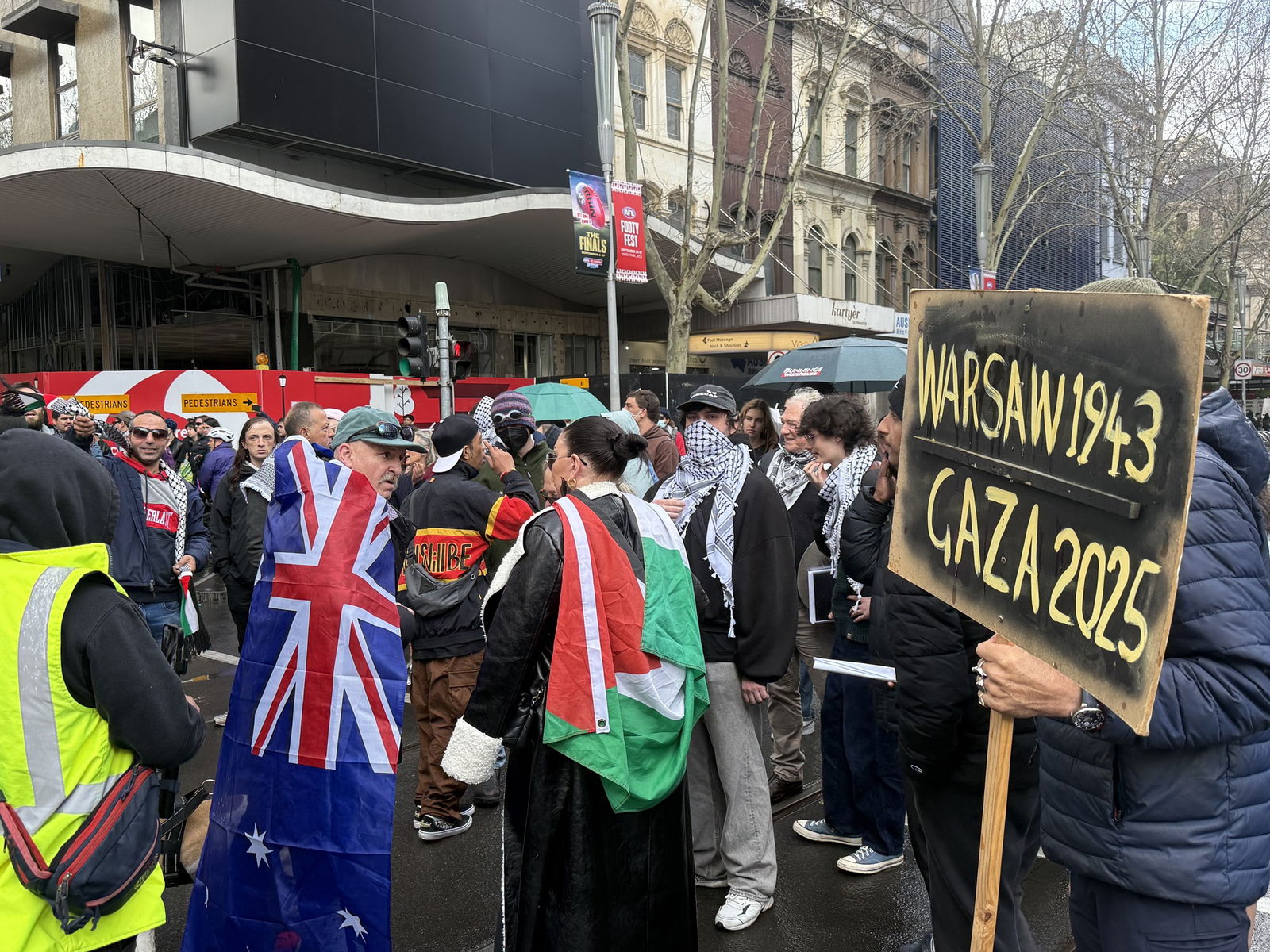 Una persona envuelta en una bandera australiana se encuentra entre los manifestantes pro-palestinos