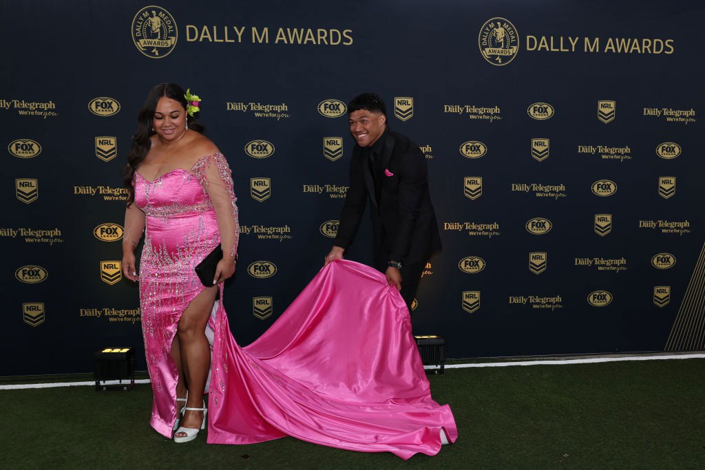 Brian To'o holds the train of wife Moesha's dress.