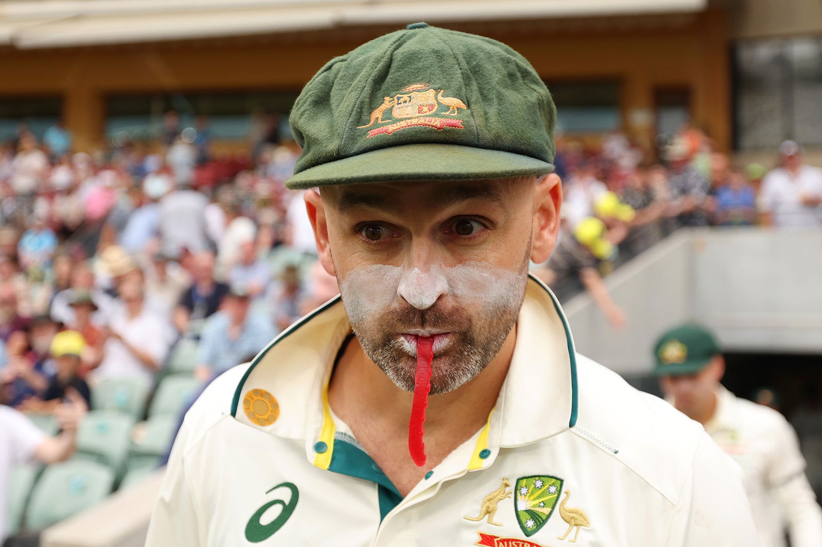 Nathan Lyon with a snake in his mouth.