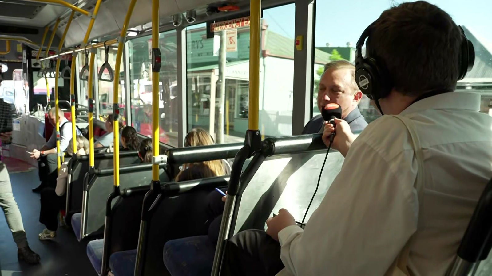 A man being interviewed on a bus.