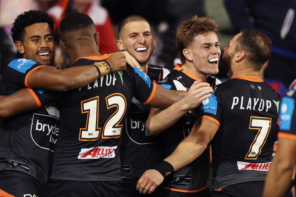  Wests Tigers players hug after an NRL try.