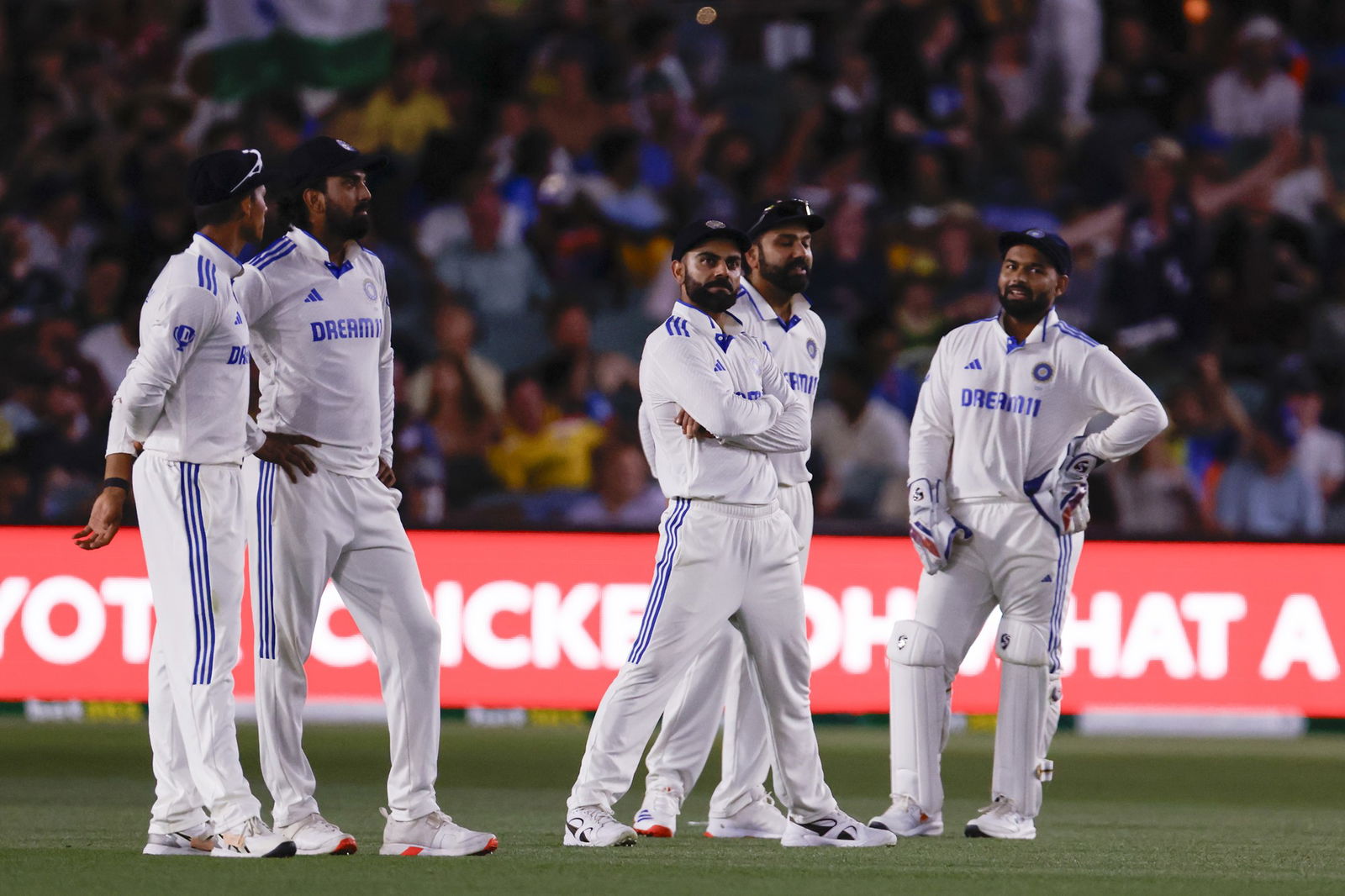 Virat Kohli and India fielders stand on the Adelaide Oval after the lights go out