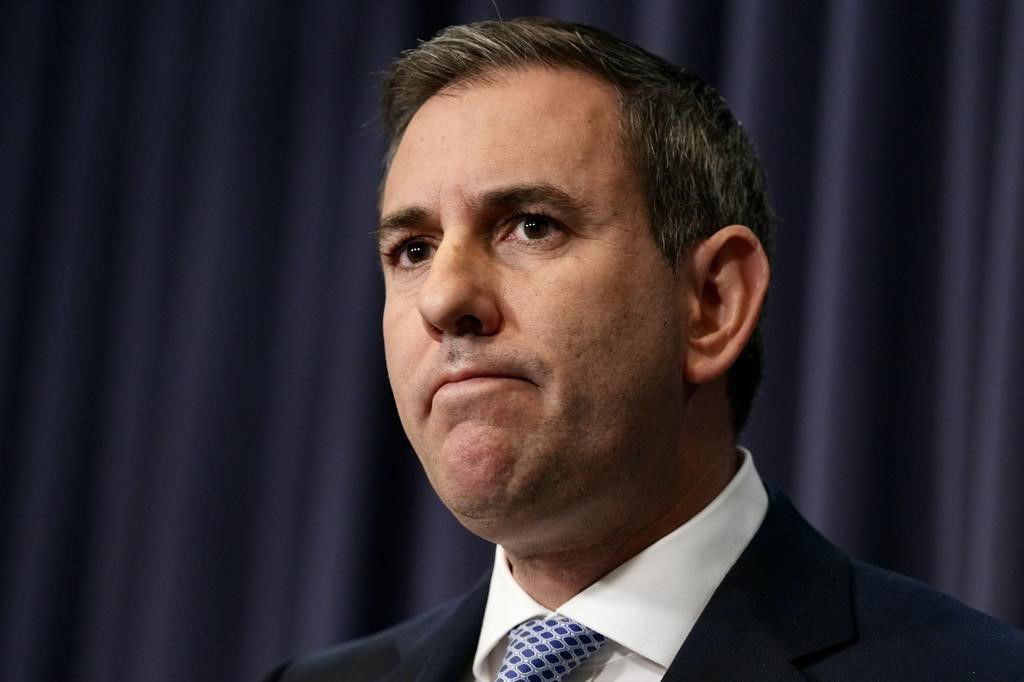 Jim Chalmers é um vínculo com um fundo azul no parlamento de Canberra.