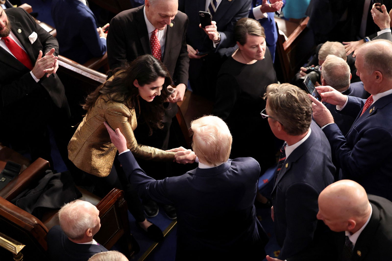 People gather on the floor of the chamber.