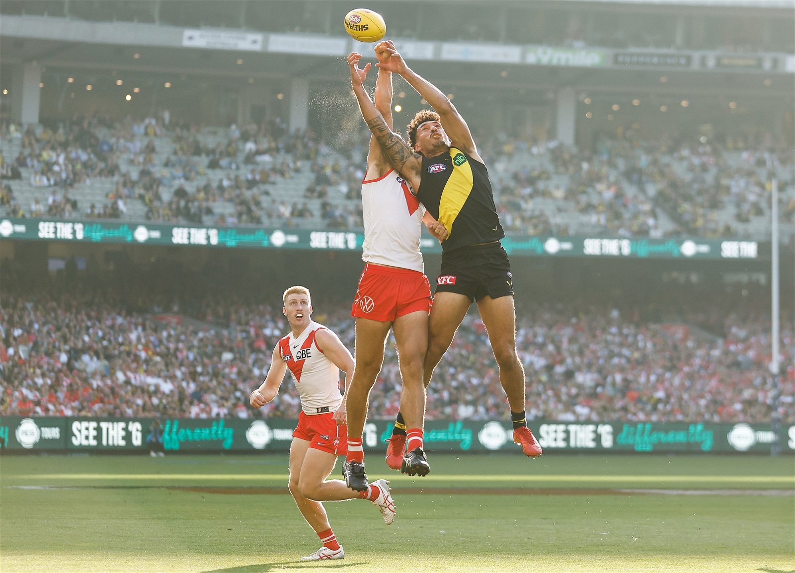 Swans and Tigers players compete for the mark