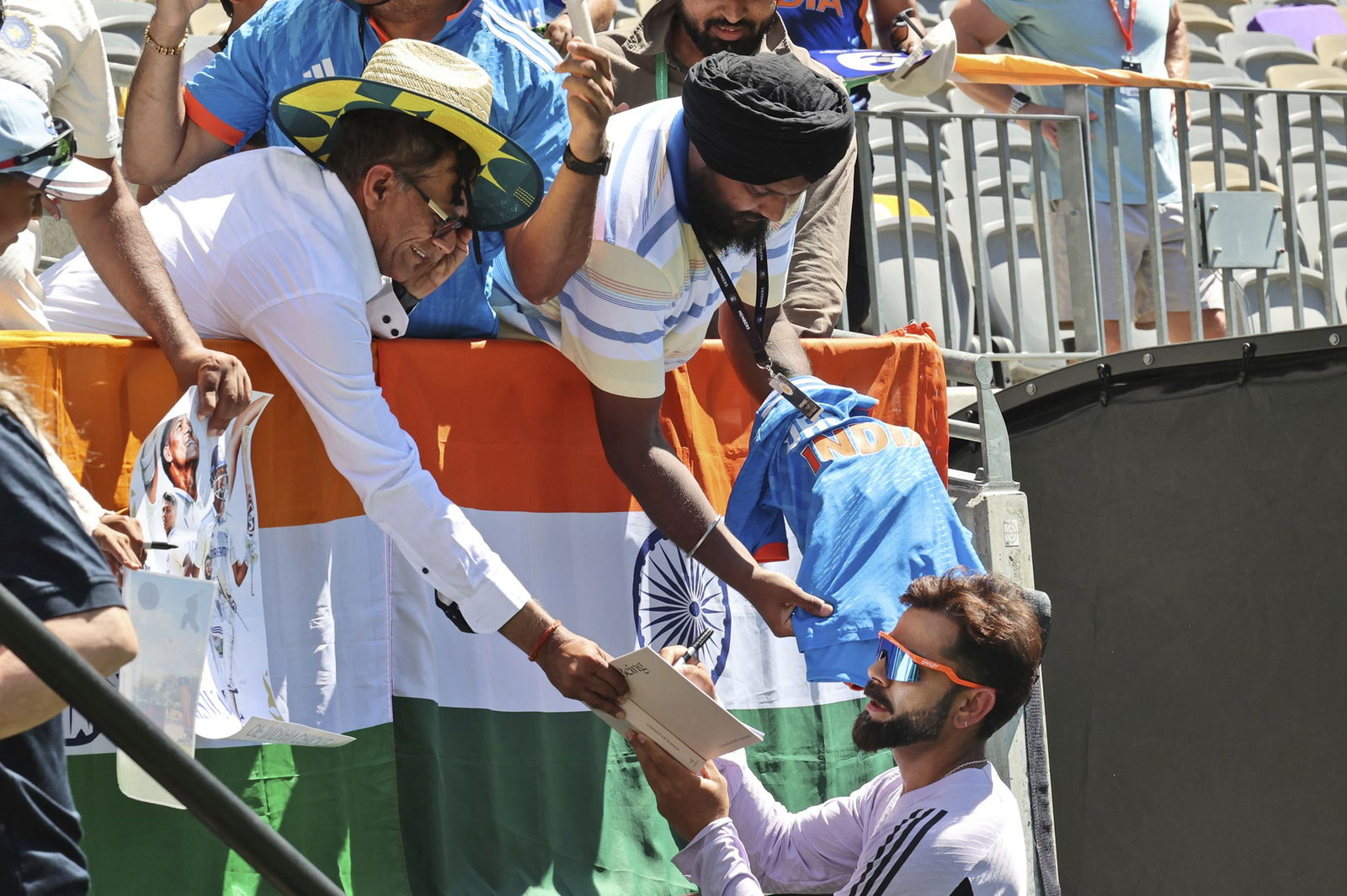 India player Virat Kohli signs autographs for fans.