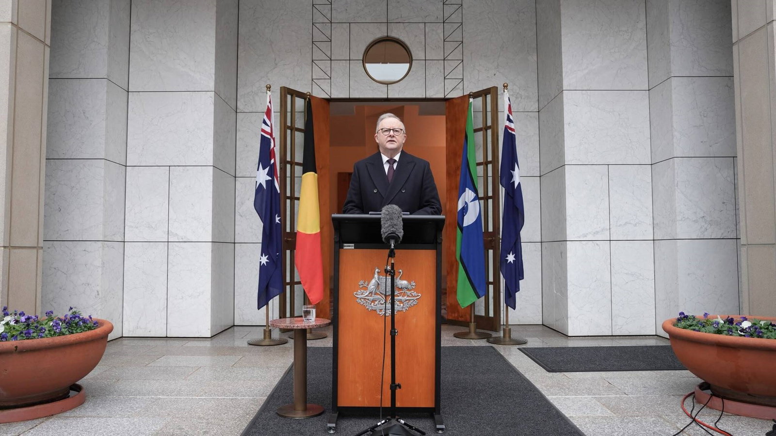 A wide shot of the PM speaking at a podium.