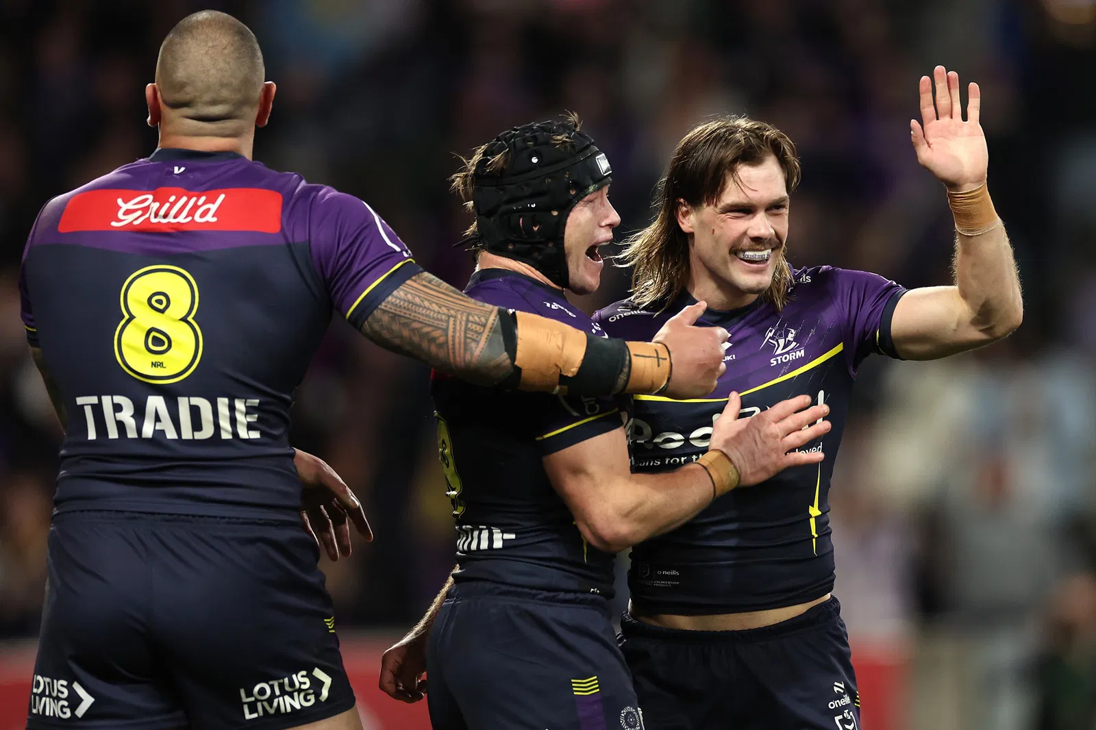 Melbourne Storm's Ryan Papenhuyzen holds his hand up as he is hugged by teammate Harry Grant.