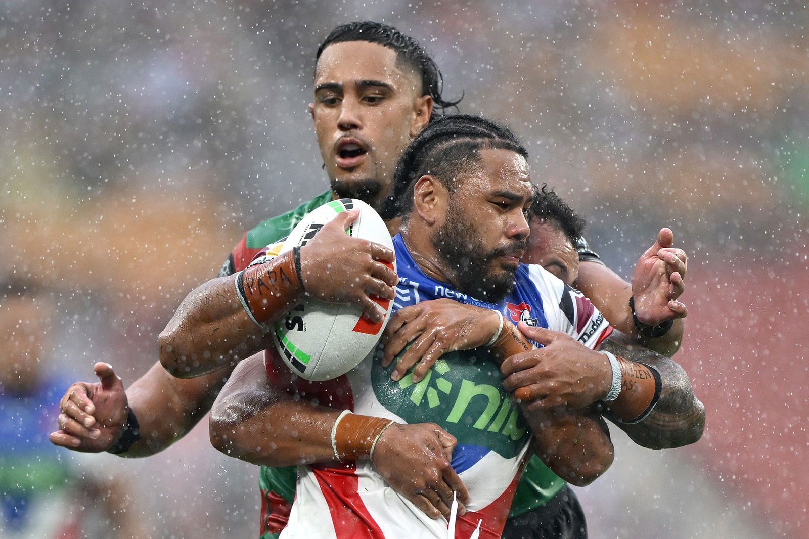Greg Marzhew is tackled by Keaon Koloamatangi in the rain.