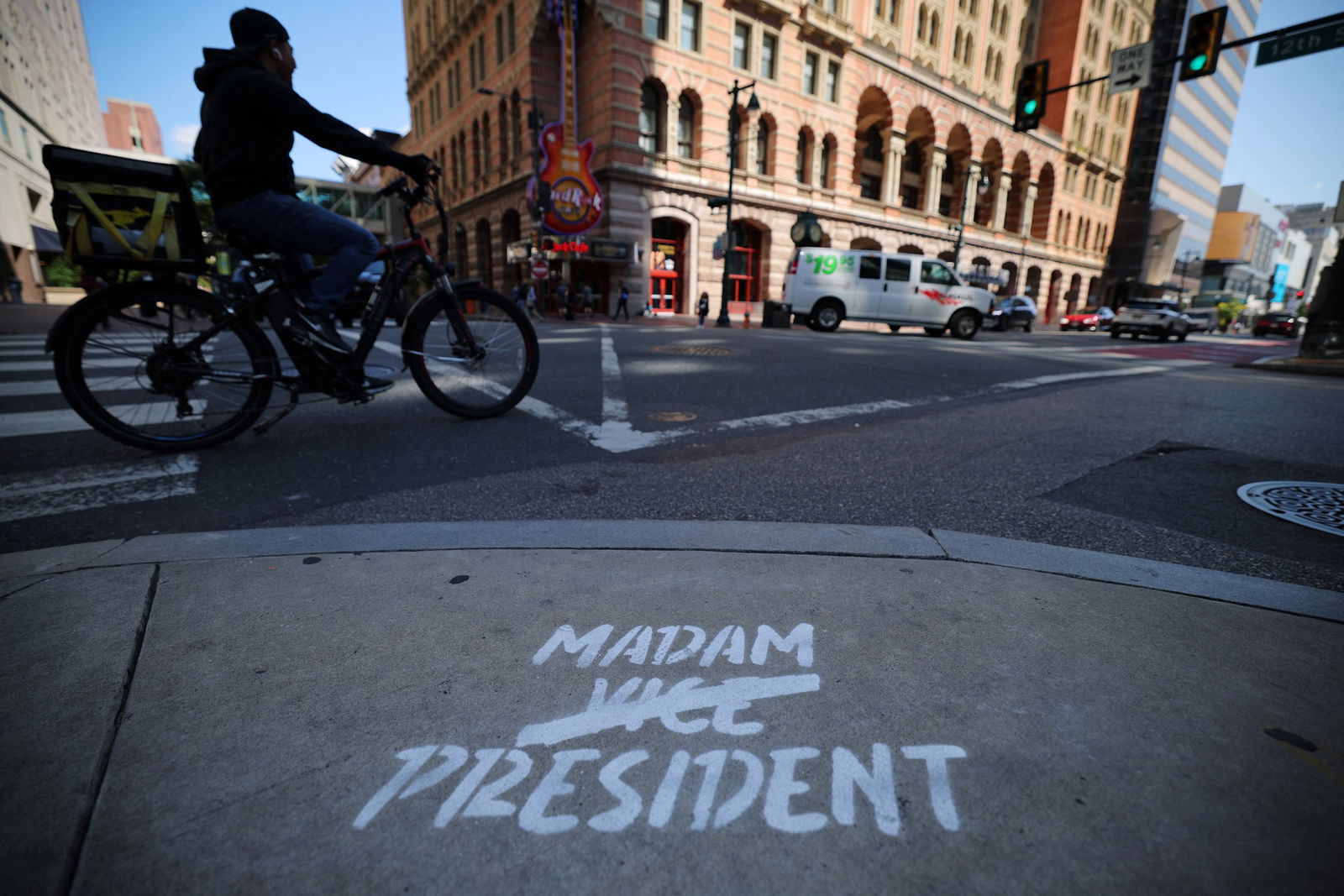 Madam Vice President spraying paint on the floor of a city street