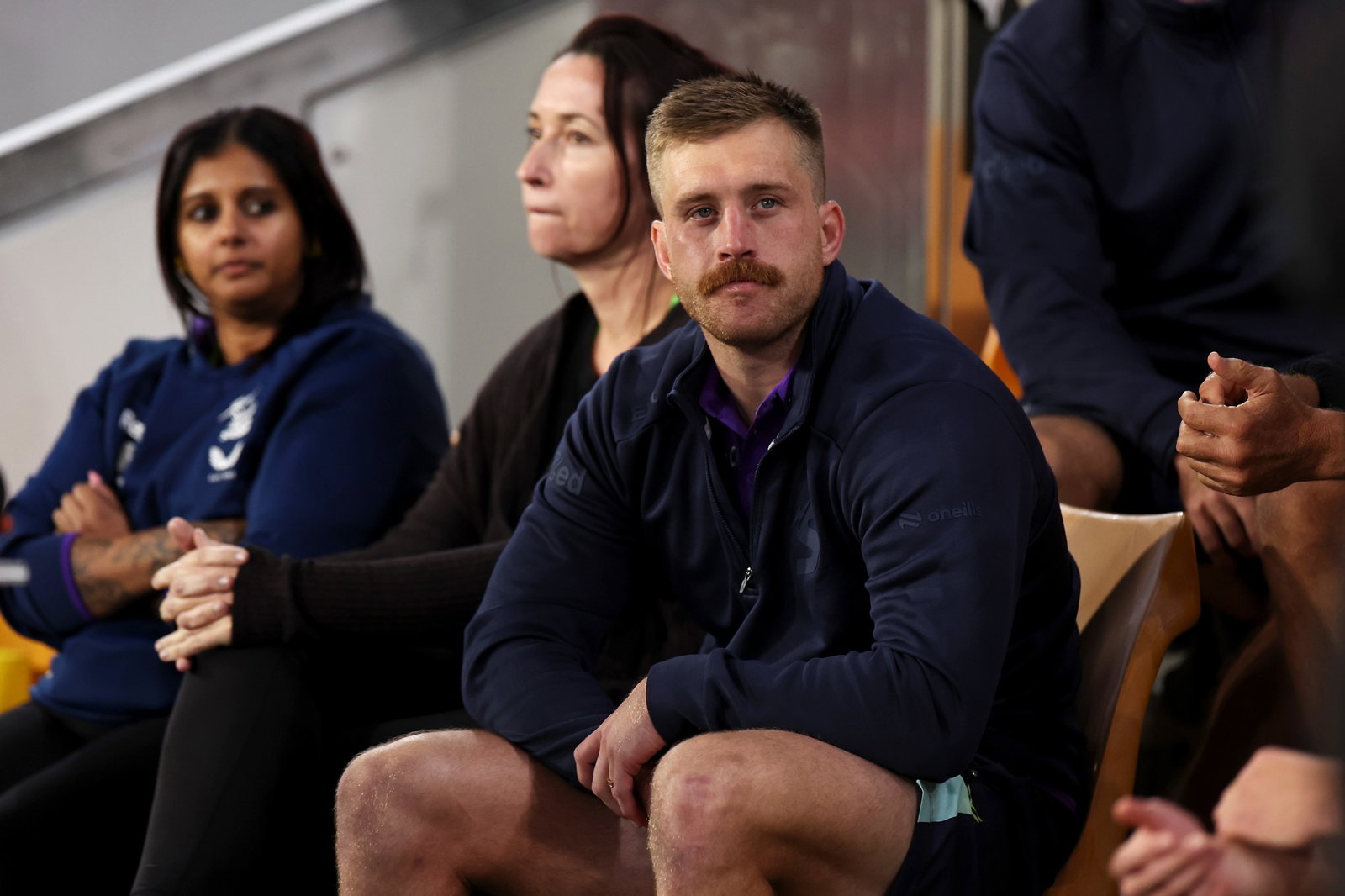 Melbourne Storm's Cameron Munster sits on the sidelines after being injured during an NRL game.
