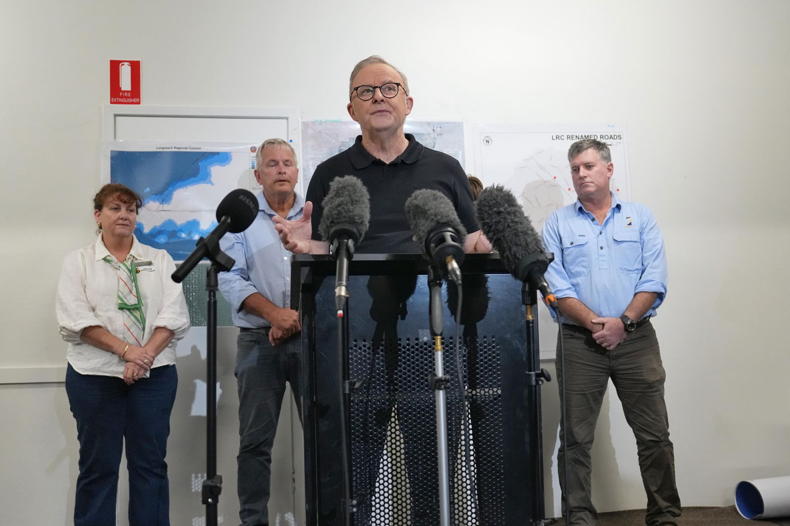 The PM is flanked by several others behind him at his press conference.
