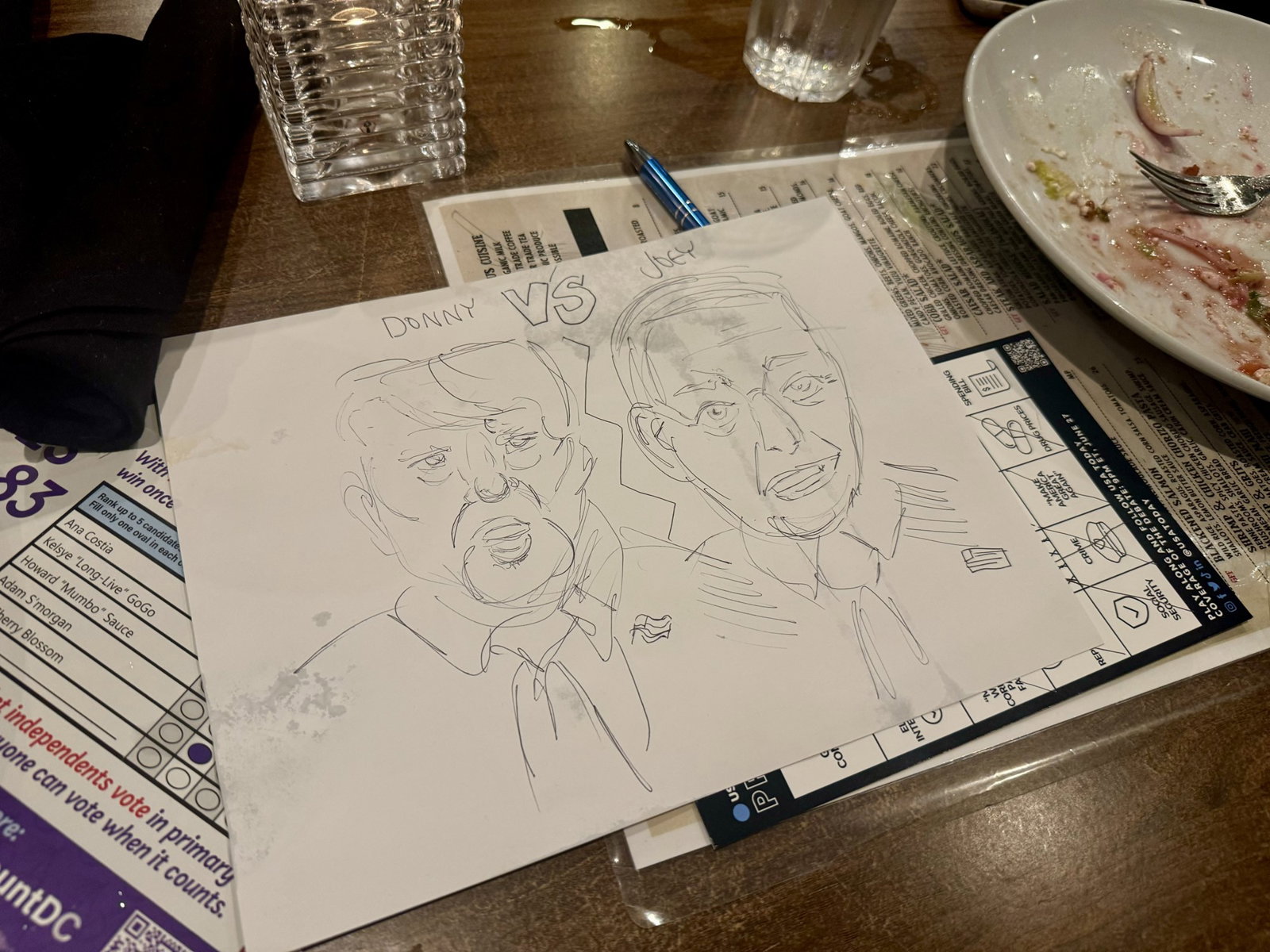 A drawing of Donald Trump and Joe Biden on a table at a pub