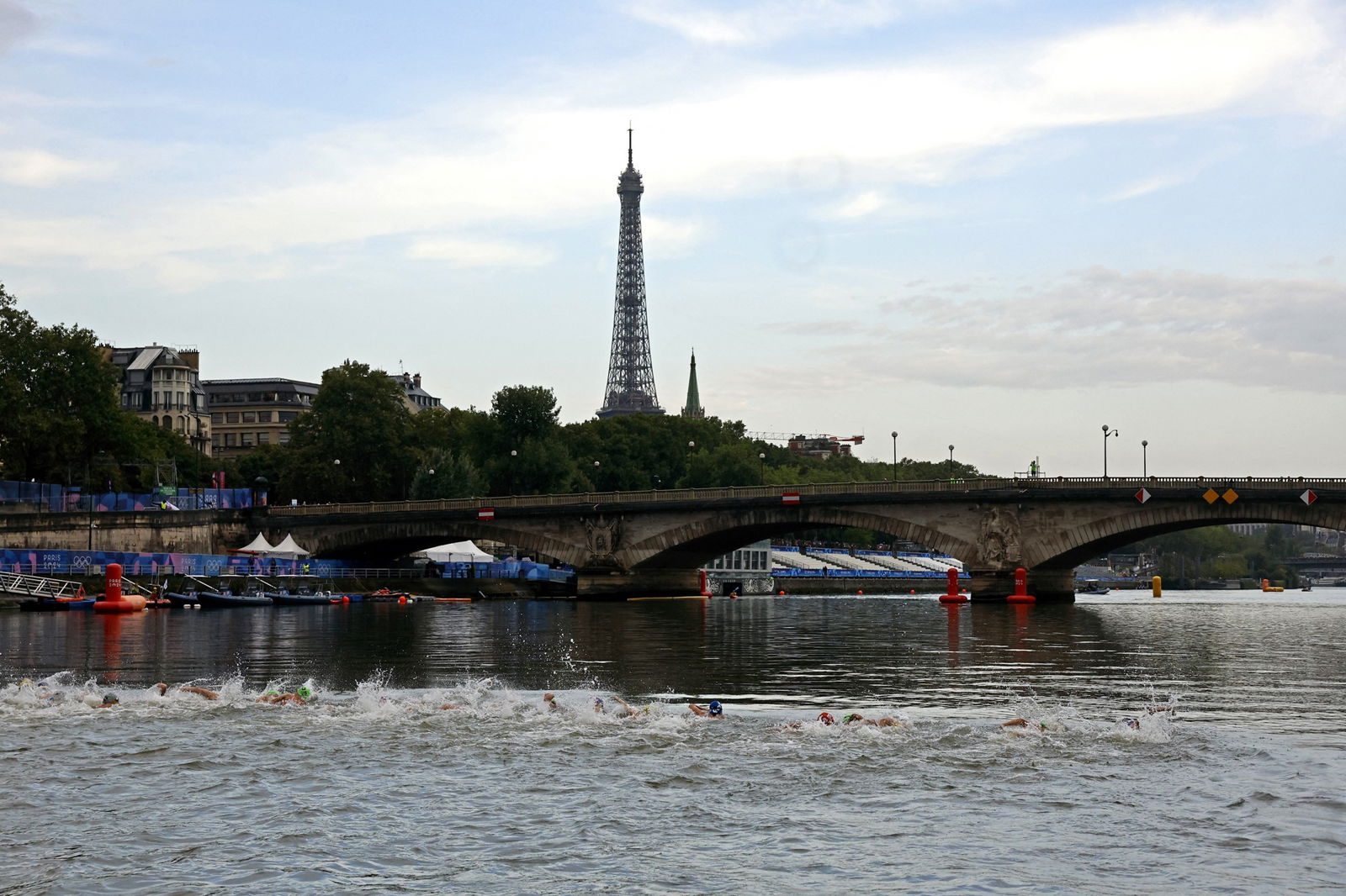Olympic female triathlon competitors swim in the iver Seine in Paris