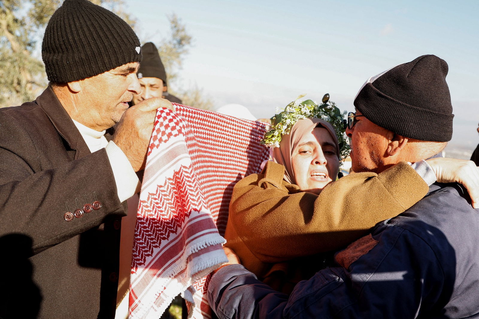 A person puts a keffiyeh on freed Palestinian prisoner Nidaa Zaghebi 