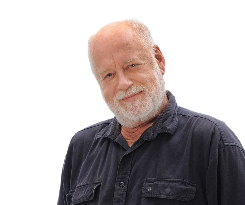 An older white man with a grey beard, wearing a black shirt, smiles.