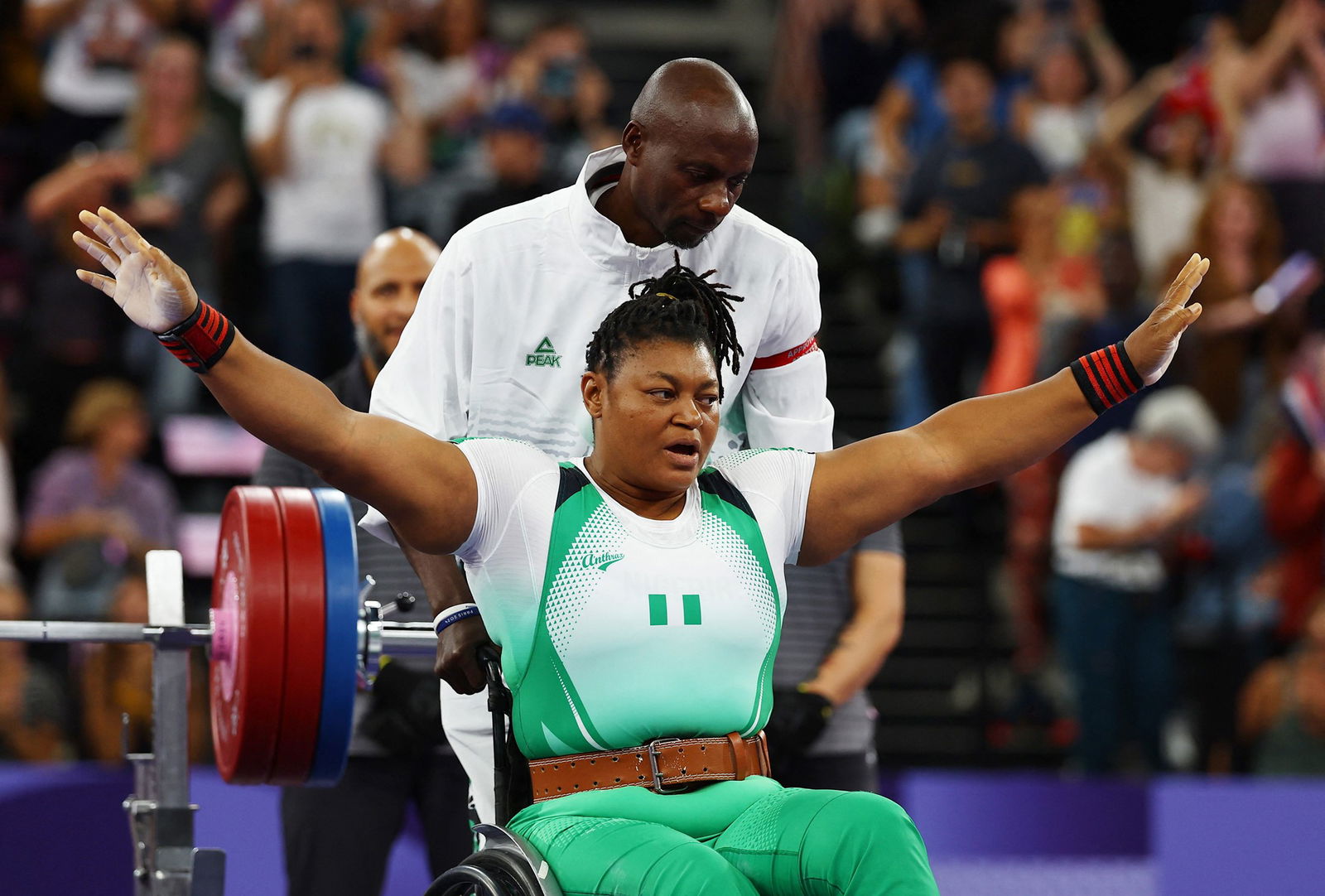 Nigeria's Folashade Oluwafemiayo sits in her wheelchair and has her arms outstretched in celebration.