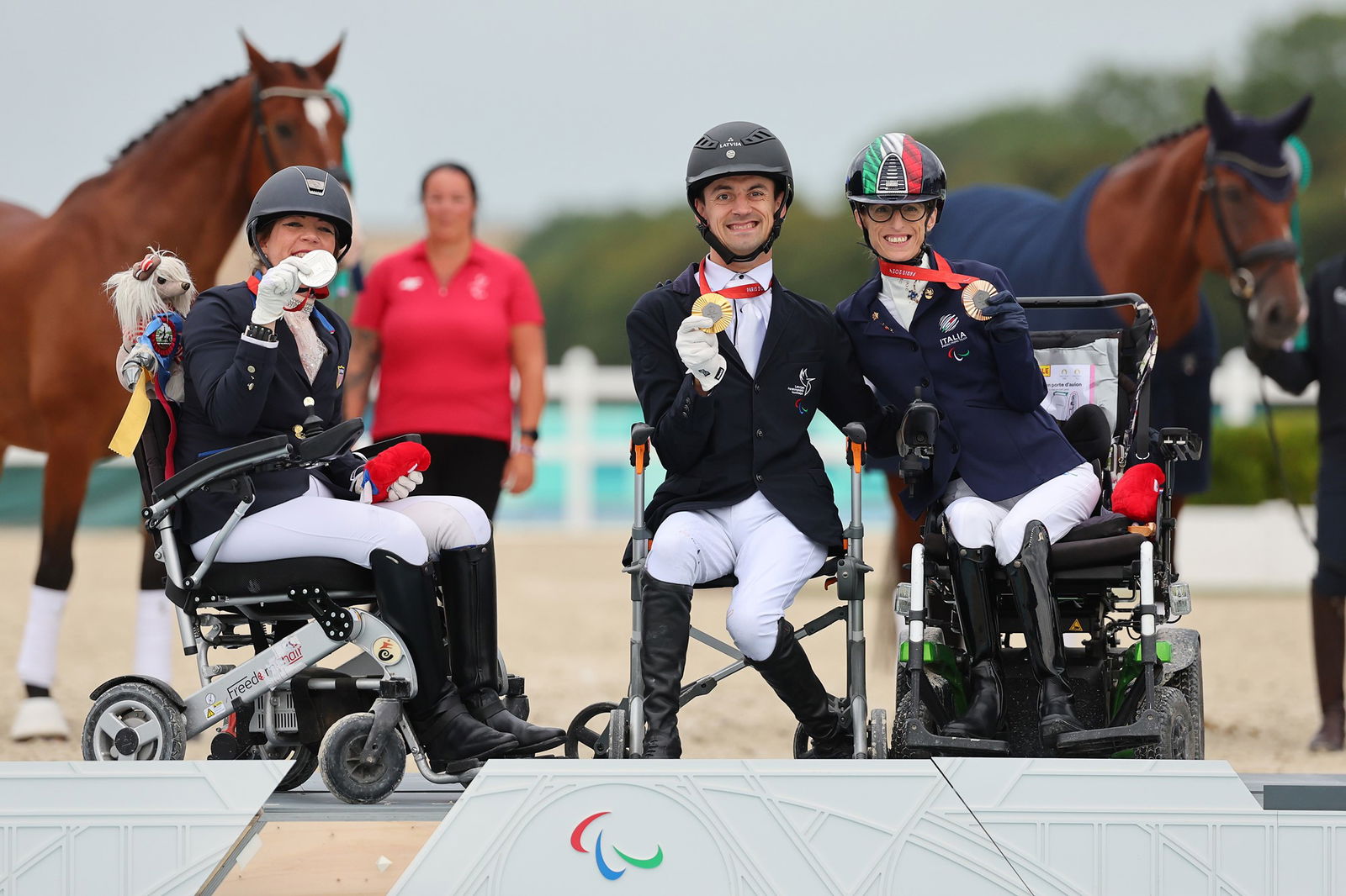 Gold medallist Latvia's Rihards Snikus (C), silver medallist Roxanne Trunnell of the US (L) and bronze medallist Sara Morganti of Italy (R) pose during Para equestrian individual grade 1. 