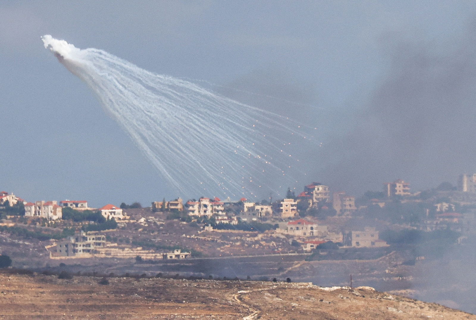 A ball of smoke with tendrils reaching down to buildings below