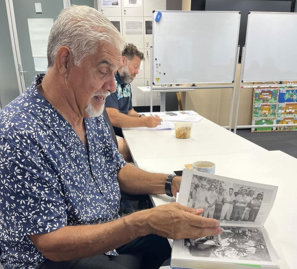 A man with grey hair flips through a book