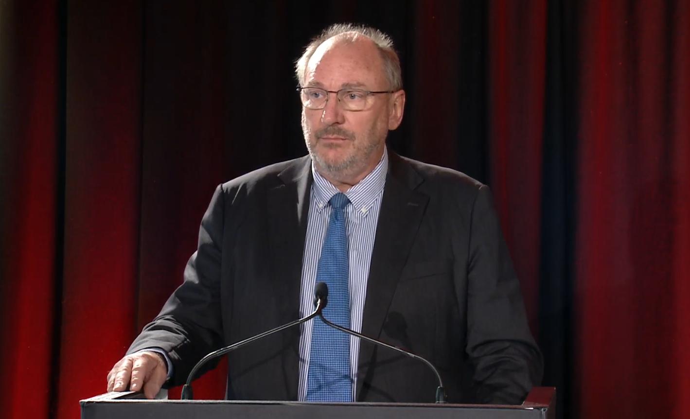 Qantas chair John Mullen stands behind a lectern.