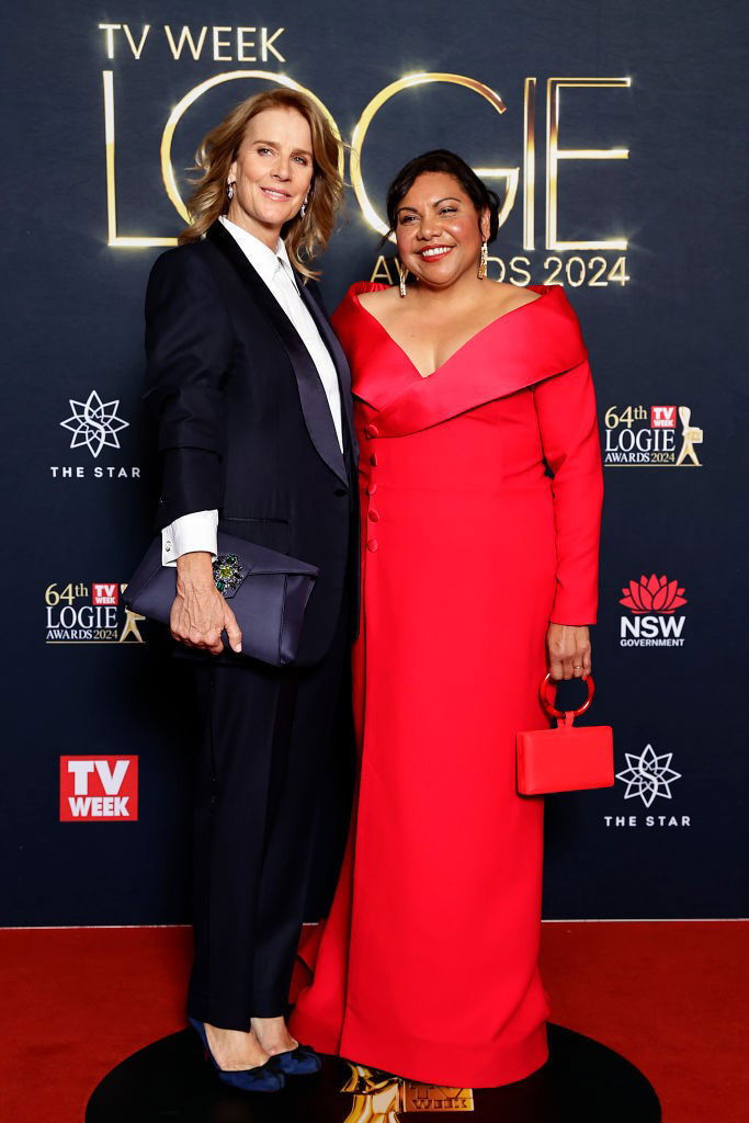 Rachel Griffiths, in a suit, and Deborah Mailman, in a red dress, pose together on the Logies red carpet.