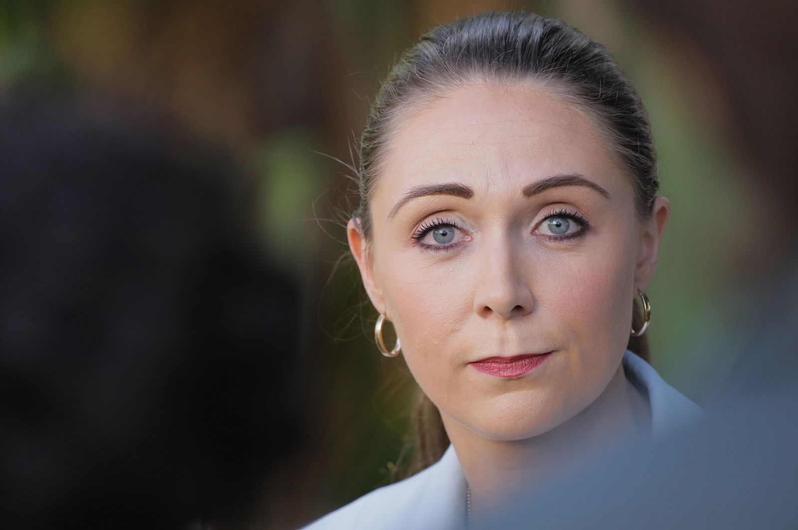 A woman looks into the camera.